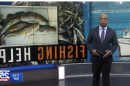 新闻广播员站在鱼的照片前，上面写着钓鱼的帮助
